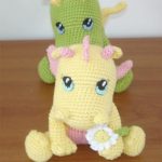 Adorable Crochet BB Dragon. yellow dragon sitting at the front with a daisy and the green dragon sitting behind || thecrochetspace.com
