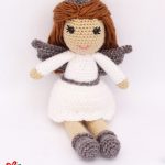 Amigurumi Christmas Angel Doll. In sitting position with white dress, grey boots and grey wings || thecrochetspace.com