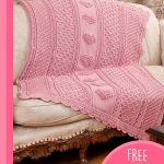 Aran Hearts Crocheted Throw. Pink throw on sofa with crocheted hearts || thecrochetspace.com