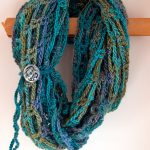 Artfully Simple Crocheted Infinity Scarf. crafted in blues and green, with one accent button at side || thecrochetspace.com