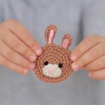 Bunny Face Crochet Applique, Only One Bunny Face Being held In Child's Fingers || thecrochetspace.com