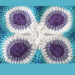 Crochet Butterfly Peacock Mandala. Close up of peacock eyes in white, blues and mauve || thecrochetspace.com