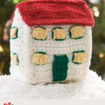 Crochet Christmas Festive Village. The larger building sitting in snow || thecrochetspace.com