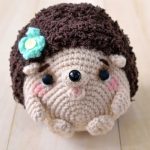Crochet Hedgehog Amigurumi. Mini hedgehog crafted in beige with brown back and a flower || thecrochetspace.com