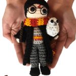 Crochet Mini Harry Potter. Image of Harry in front of a pair of hands to show his size. Wearing a scarf and holding an owl || thecrochetspace.com
