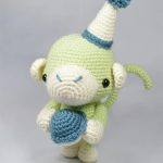 Crochet Party Monkey. Crafted in shades of green with a hat and ball || thecrochetspace.com