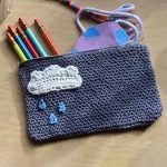 Crochet Pencil Case. Grey pencil case with filling spilling out onto desk || thecrochetspace.com