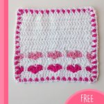 Crochet True Love Ways Dishcloth. Entire dishcloth showing pink edging and 2x rows of pink hearts || thecrochetspace.com