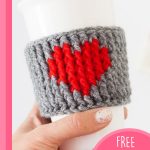 Crocheted Heart Cup Warmer. Hand lifting cup with mug cozy around it || thecrochetspace.com