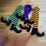 Crocheted Witches Legs Scarf. Stripey legs in black and green or purple or yellow with black boots || thecrochetspace.com