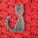 Cute Cat Crochet Applique. Little brown cat on red crochet background || thecrochetspace.com