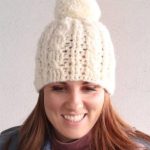 Heavy Crochet Cable Hat. Front view of cream hat with pompom || thecrochetspace.com