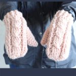 Heavy Crochet Cable Mittens. Hands in pair of pink twisted cable mittens || thecrochetspace.com