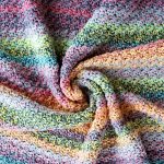 Hooked On Home Made Happiness. middle of the blanket laying open and pinched into a swirl. Colorful. Variegated || thecrochetspace.com