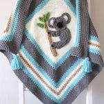 Kute Koala Crochet Blanket hanging on a ladder. Blue tassels at each corner || thecrochetspace.com