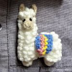 Larry Llama Crochet Brooch. pinned onto a grey shirt || thecrochetspace.com