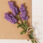 Lovely Lavender Crochet Spray. Three blooms at an angle with heads laying on small square of brown paper || thecrochetspace.com