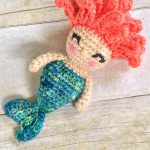 Mini Mermaid Crochet Rattle. Laying on a wooden surface || thecrochetspace.com
