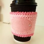 Mug Hugger Crocheted Coffee Cozy. Dusky pink mug cozy with darker, dusky pink edging with accent label on front || thecrochetspace.com