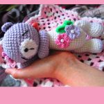 Sleeping Crocheted Teddy Bear. Crafted in mauve & white and with accent flowers || thecrochetspace.com