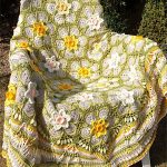 Spring Narcissus Crochet Cal. Blanket thrown over chair. Crafted in green with flowers of the garden || || thecrochetspace.com