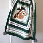 Super Sloth Crochet Blanket crafted in different shades of green and white contrast with sloth in the middle || thecrochetspace.com