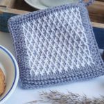 Typical Tunisian Crochet Potholder. Border of plain grey and then an inserted inlay of white contrasting diamonds || thecrochetspace.com